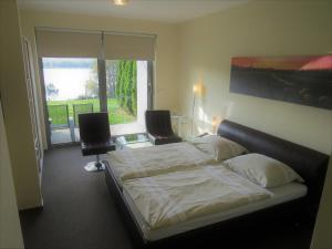 a bedroom with a bed and a desk and a window at Šiker B&B Hotel in Pernica