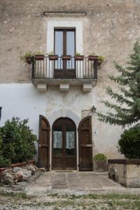 a building with a balcony and a door with a window at MASSERIA CITULO Il Pino grande in Castel del Monte