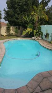 a large blue swimming pool in a yard at 10 On Ou Kraal in Edgemead