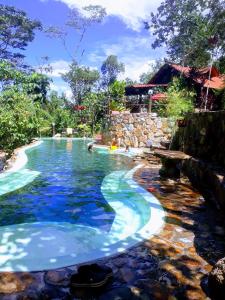 una piscina en un complejo con agua azul en Finca de la Vaca - Glamping & Camping, en Mera