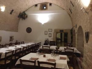 a dining room with tables and chairs in a building at MASSERIA CITULO Il Pino grande in Castel del Monte +21 photos