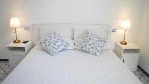 a white bed with two night stands and two lamps at Villa Mary - Apartment in Trani