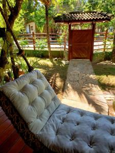 un sofá blanco sentado en un porche con una valla en Bangalô alto do Mucugê, en Arraial d'Ajuda