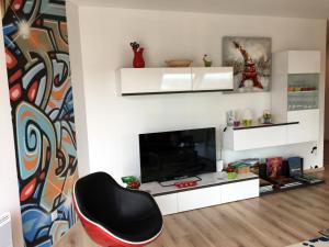 een woonkamer met een stoel en een tv bij La Seine en couleurs - juste rénové in Duclair