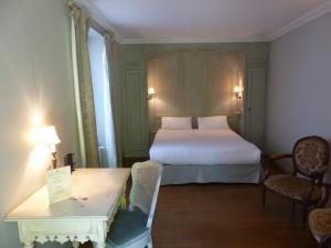 um quarto de hotel com uma cama, uma mesa e cadeiras em Résidence Charles Quint em Besançon