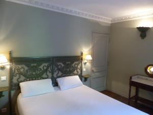 um quarto com uma cama branca e 2 almofadas brancas em Résidence Charles Quint em Besançon