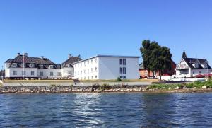 um grupo de casas na costa de uma massa de água em Hotel Udsigten Marstal em Marstal