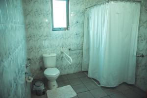 a bathroom with a toilet and a shower curtain at Cabañas Shangrila Aysen in Puerto Aisén +175 photos