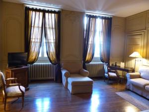 a living room with a couch and chairs and windows at Résidence Charles Quint in Besançon