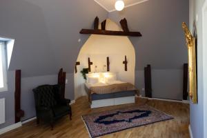 1 dormitorio con cama, silla y espejo en Hotell Hjalmar, en Örebro