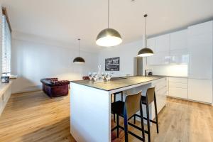 a kitchen with white cabinets and a bar with stools at Center Apartment, Vilnius, Old Town in Vilnius +8 photos