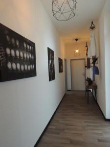 einen Flur mit Gemälden an den Wänden eines Zimmers in der Unterkunft Zentrales Apartment in Gelsenkirchen in Gelsenkirchen