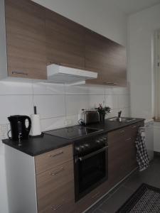 a kitchen with wooden cabinets and a stove top oven at Zentrales Apartment in Gelsenkirchen in Gelsenkirchen