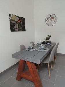 a dining room table with chairs and a clock on the wall at Zentrales Apartment in Gelsenkirchen in Gelsenkirchen