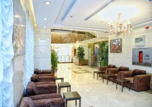 a lobby with couches and tables and a chandelier at Nasamaat Ajyad Hotel in Mecca