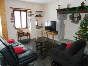 uma sala de estar com uma árvore de Natal e uma lareira em La petite maison em Tauves
