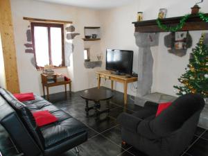 a living room with a christmas tree and a fireplace at La petite maison in Tauves