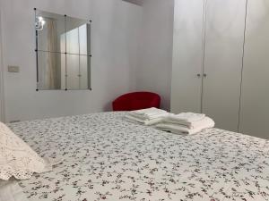 a bedroom with a bed with towels on it at Temporary House Oberdan in Bologna +70 photos