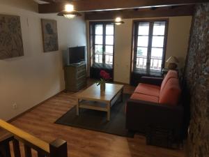 ein Wohnzimmer mit einem roten Sofa und einem Couchtisch in der Unterkunft Bonita Casa en Pontedeume in Puentedeume