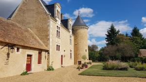 ein Gebäude mit einem Turm und einem Schloss in der Unterkunft Manoir de la Beunèche - location du manoir entier in Roézé-sur-Sarthe