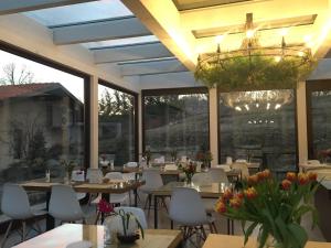 a restaurant with tables and chairs and a chandelier at Home Holiday "Da Mamma" in Alba