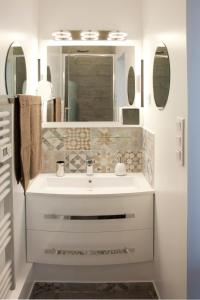 a bathroom with a white sink and a mirror at Le Moulin de PEBRE in La Ciotat
