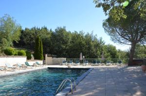 una piscina con tumbonas y una piscina en Les Hiboux du Domaine du Moulin, en Étables