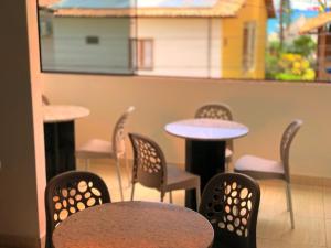 a group of tables and chairs in a restaurant at Pousada Paraíso Maragogi in Maragogi