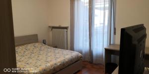 a small bedroom with a bed and a television at Casa della Sala Spada in Casale Monferrato