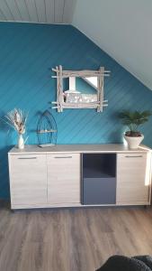 una sala de estar con una pared azul y un armario en Gîte "L'Escapade Marine", en Cancale