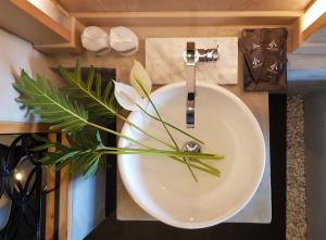 a bathroom sink with a flower arrangement on it at Aurico Kata Resort & Spa - SHA Extra Plus in Kata Beach