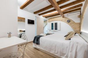 タラゴナにあるHostal 977のベッドルーム(白い大型ベッド1台、デスク付)