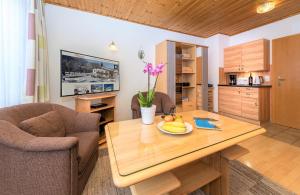 - un salon avec une table en bois et un bol de fruits dans l'établissement Appartements Haus Sonnenschein, à Zell am See