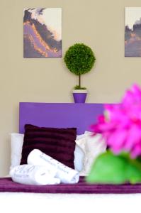 a purple bed with white pillows and a potted plant at Rehoboth Mountain Suites in Mbabane
