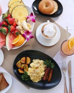 a table topped with plates of food and fruit at Beacon South Beach Hotel in Miami Beach