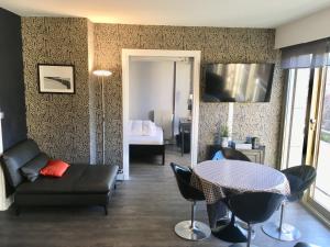 a living room with a table and a couch at Superbe appartement contemporain in Le Touquet-Paris-Plage