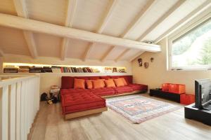 sala de estar con sofá rojo y TV en Design loft ski in ski out en La Thuile
