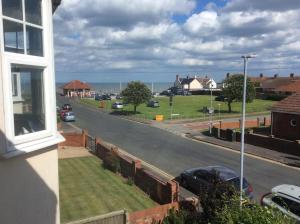 uma vista para uma rua com carros estacionados na estrada em Merlstead House em Hornsea