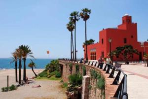 a group of people standing on a wall near the beach at Green Views Benalmadena in Benalmádena