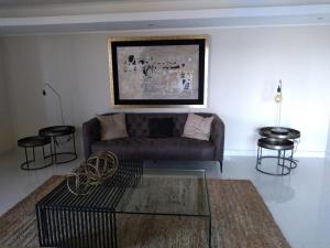 ein Wohnzimmer mit einem Sofa und einigen Tischen und Stühlen in der Unterkunft Departamento Reñaca maravillosa vista al mar in Viña del Mar