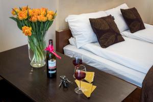 una mesa con un jarrón de flores y dos copas de vino en Abra Apartment, en Cracovia