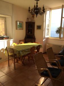 una sala da pranzo con tavolo e sedie e una cucina di appartamento Le Vele a Gargnano