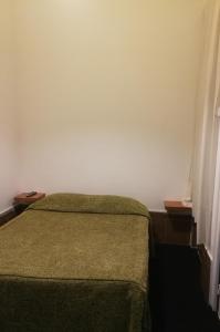 um quarto com uma cama verde e uma parede branca em Residencial do Sul em Lisboa