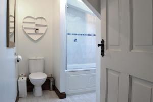 a bathroom with a toilet and a heart on the wall at Petrock Holiday Cottages in Newton Saint Petrock