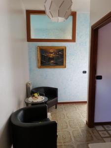 - un salon avec une chaise noire et une table dans l'établissement B&B Dolce Casa, à Panicarola