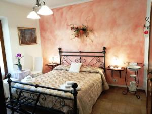 a bedroom with a bed and a pink wall at Pacifico in Montepulciano