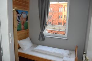 a bed with two pillows and a window at Hamburger Alm Hotel St. Pauli in Hamburg