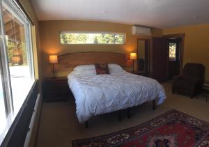 a bedroom with a large bed and a window at Comforts of Whidbey in Langley