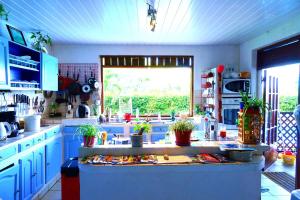 a kitchen with blue cabinets and a large window at Villa Vaiana EURL Vaiana Faratea officedu tourisme 1593DTO MT in Paopao
