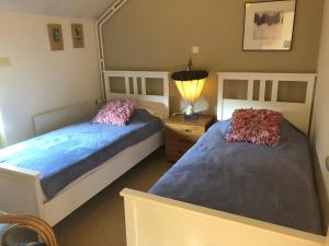 a bedroom with two beds and a lamp at Holiday home Elena in Slenaken